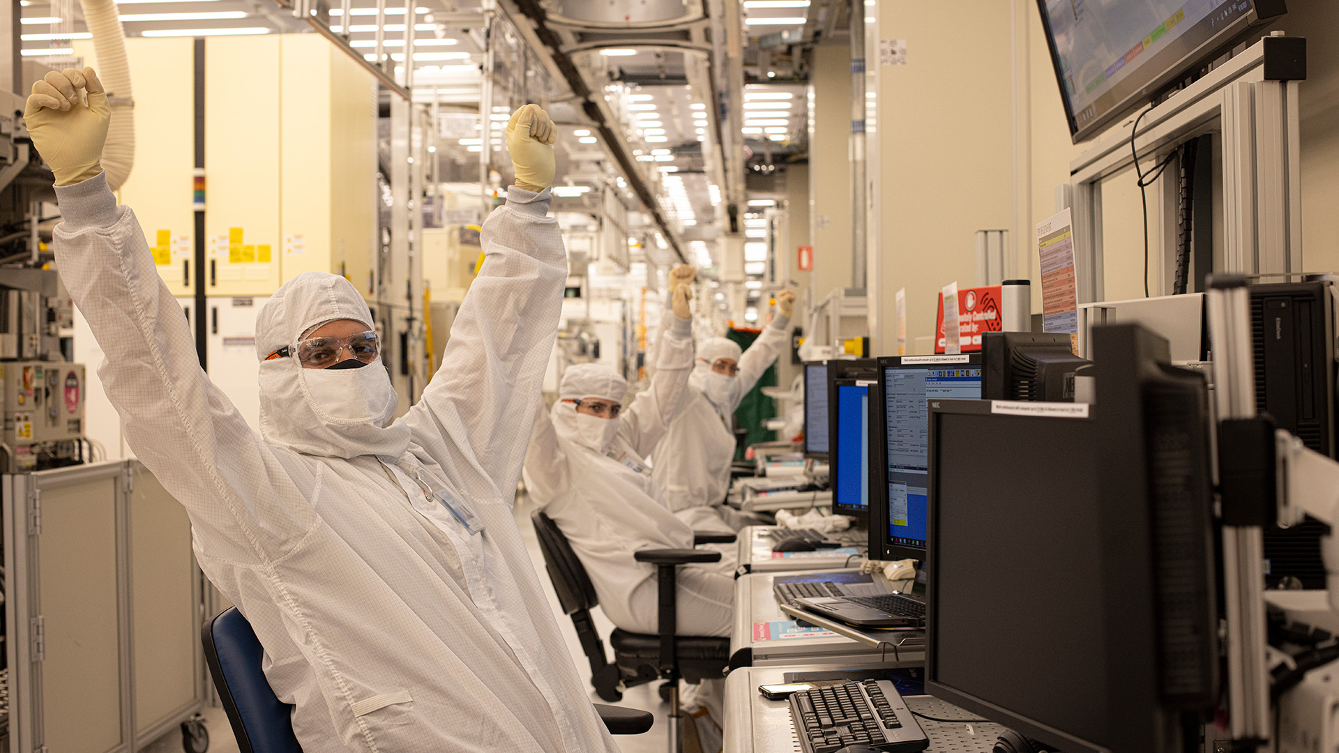 Intel engineers sat at desks in the fab cleanroom.