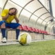 A footballer holds their head in their hands after hearing about eFootball