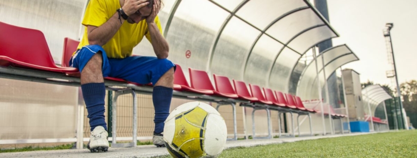 A footballer holds their head in their hands after hearing about eFootball