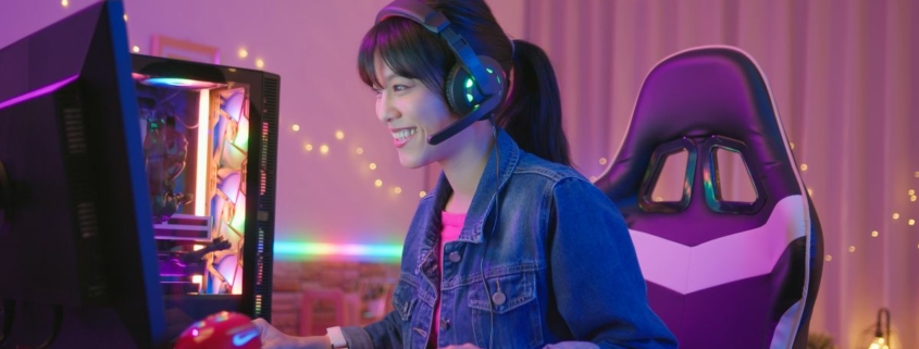 asian woman gamer wearing headset is chatting with player while playing in online video game at home