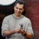 Henry Cavill holding a Warhammer figure.