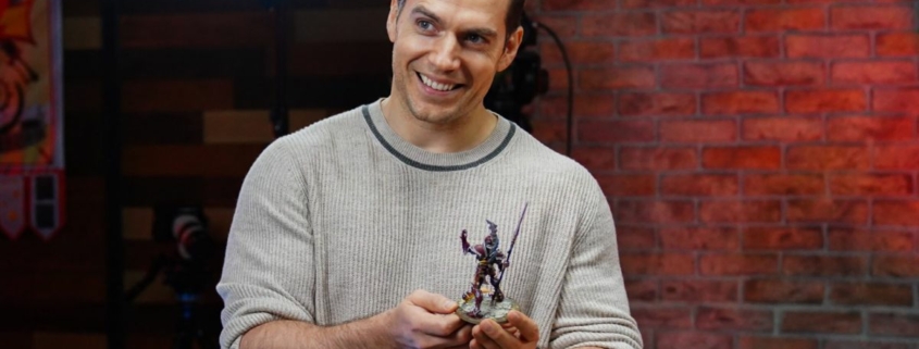 Henry Cavill holding a Warhammer figure.