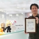 Yoshinori Kitase, producer on FF7 Remake, holding a commemorative certificate marking Final Fantasy 7 Day.