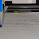 3d printer with a pen on it writing on paper.