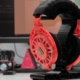 Ploopy Headphones on a headset stand in front of a monitor