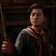 Hogwarts Legacy - A Gryffindor student holds his wand up while standing in Hogsmeade.