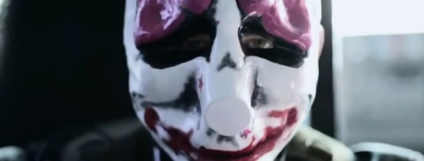 A close-up of a live-action actor wearing a Payday clown mask.