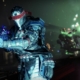 A Guardian holds their sniper rifle. In the background, a Shadow Legion fires a volley of rockets.