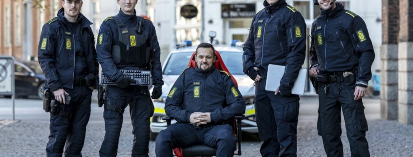 The Danish Police Online Patrol unit, standing in a line and holding gaming peripherals.