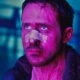 Ryan Gosling looking worse for wear looking up lit by purple light