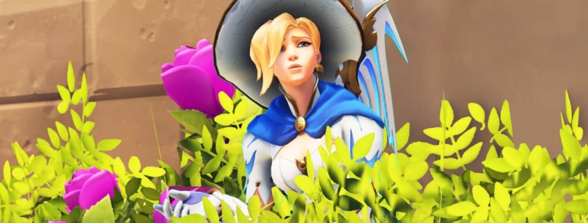 Mercy from Overwatch hiding in a bush. She is shrugging. She seems confused.