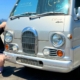 Ludwig Ahgren poses beside his dream car, a Subaru Sambar microvan.