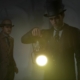 Sherlock Holmes and Watson investigate by the light of a lantern in Sherlock Holmes: The Awakened.