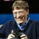 Bill Gates in 2005 holding an Xbox controller and smiling.