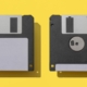 Close-Up Of Two Floppy Disks Against Yellow Background