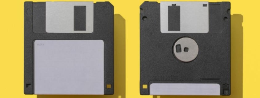 Close-Up Of Two Floppy Disks Against Yellow Background