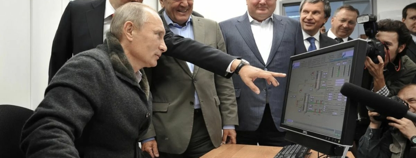 Vladimir Putin being shown something on a computer monitor