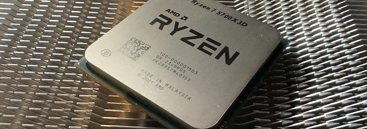 A photo of an AMD Ryzen 7 5700X3D processor resting on a metal heatsink