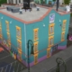 The Sims 4 - Beso Rapido, a light blue building with yellow windows and a neon sign on a city corner