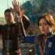 Lucy and Max from Fallout with their hands up