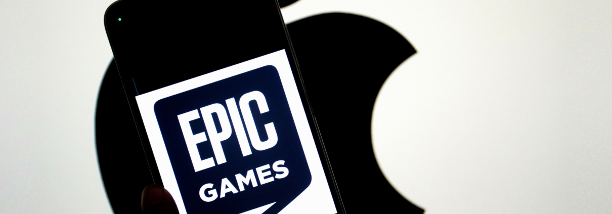 INDIA - 2024/09/14: In this photo illustration, an Epic Games logo seen displayed on a smartphone with an Apple logo in the background. The relationship between Epic Games and Apple became widely known due to a legal dispute. In 2020, Epic Games, the creator of the popular game Fortnite, challenged Apple's App Store policies by introducing a direct payment option in Fortnite, bypassing Apple's 30% commission on in-app purchases. Apple responded by removing Fortnite from the App Store, leading to a major lawsuit. Epic accused Apple of anti-competitive behavior, claiming that the company had a monopoly on app distribution and payments within its ecosystem. The case, which addressed broader issues of app store policies and digital marketplaces, attracted significant attention and sparked debate about the control tech giants have over their platforms. (Photo Illustration by Avishek Das/SOPA Images/LightRocket via Getty Images)