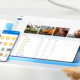 A promotional image for Microsoft OneDrive, showing a stylized collage of a tablet, phone, and application icons together