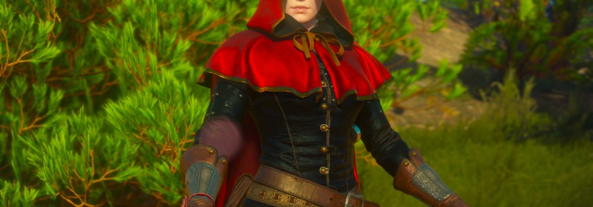 A woman in a red hood against vibrant green plant life
