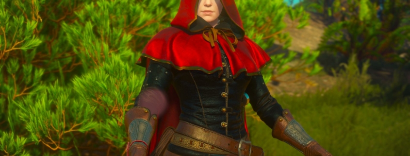 A woman in a red hood against vibrant green plant life