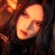 Tachy, with her face lit by fire in the background